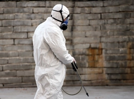 Man in hazmat suit cleaning.