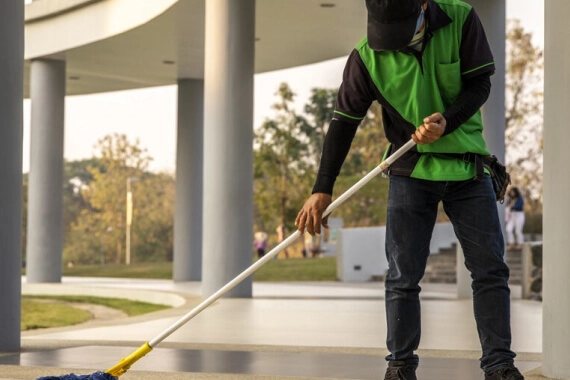 Man cleaning the floor of a building.